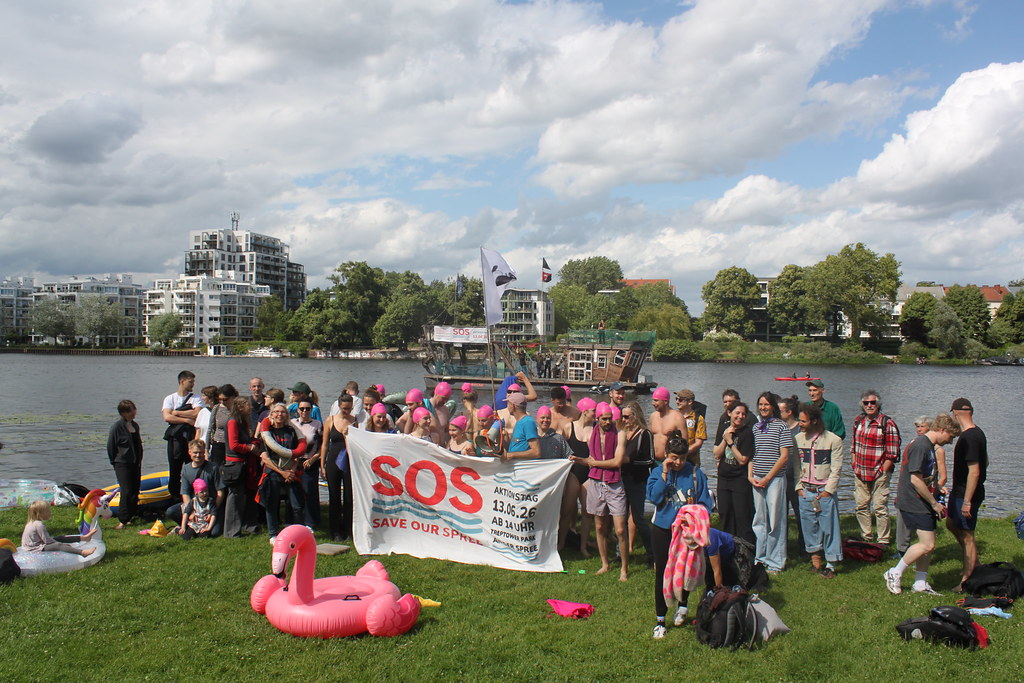 Wasseraktivist*innen stehen im Rahmen eines Aktionstags am Ufer der Spree